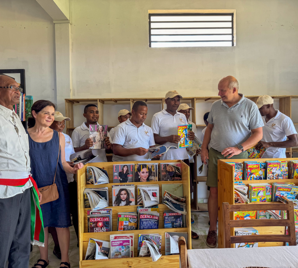 Officiels et partenaires réunis devant les étagères de livres lors de l'inauguration de la médiathèque Edmond Albius.