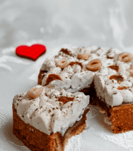 Petit gâteau meringué aux noisettes, accompagné d'un cœur rouge décoratif.